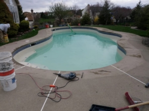 Tools and electrical cords beside swimming pool