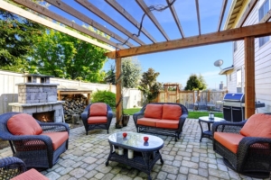 Outdoor living space transformed into beautiful entertaining area with outdoor fireplace and stone patio 